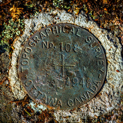 survey marker located near a fire ring at a campsite on the north end of the lake