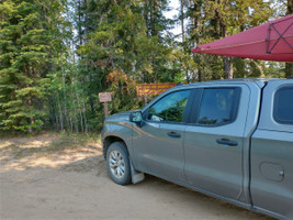 My truck and kayak by the lake sign.